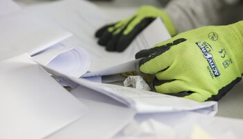 Ein Mitarbeiter entsorgt Papier | © Wendelstein Werkstätten